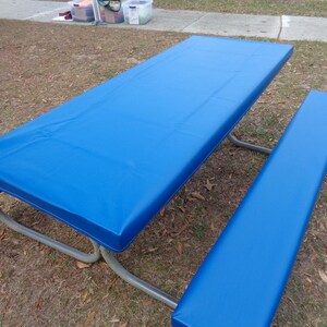 May include: A blue vinyl picnic table cover with a matching bench cover. The cover is made of a durable, waterproof material and is perfect for protecting your picnic table from the elements.