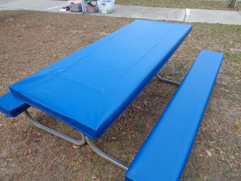May include: A blue vinyl picnic table cover with a matching bench cover. The cover is made of a durable, waterproof material and is perfect for protecting your picnic table from the elements.