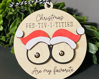 May include: A wooden Christmas ornament with a red and white Santa hat design and the text "Christmas Festiv-i-tities are my favorite".