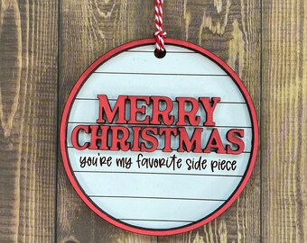 May include: Red and white wooden Christmas ornament with the text "Merry Christmas you're my favorite side piece".