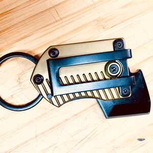 May include: A gold and black multi-tool keychain with a key ring, a small blade, and a bottle opener.
