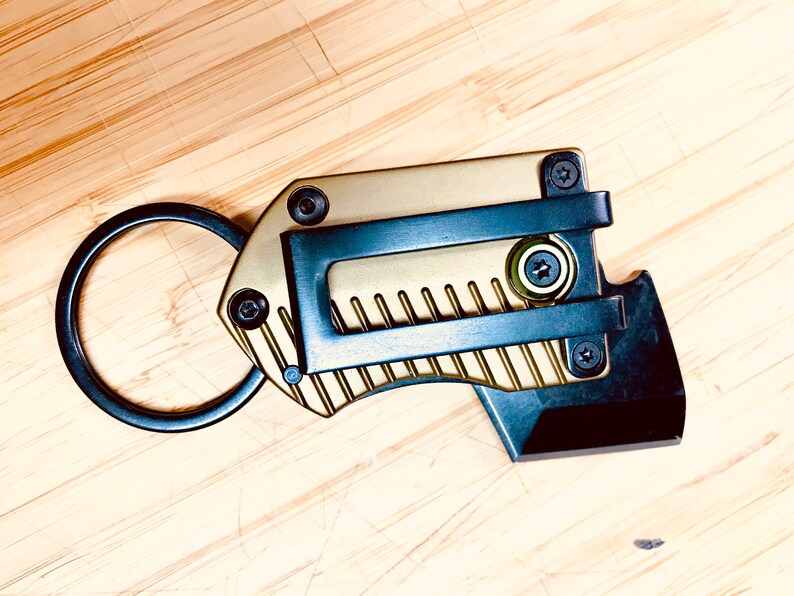 May include: A gold and black multi-tool keychain with a key ring, a small blade, and a bottle opener.