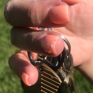 May include: A gold Gerber multi-tool with a black handle and a silver keyring. The multi-tool has a textured surface and the word "GERBER" is printed on the side.
