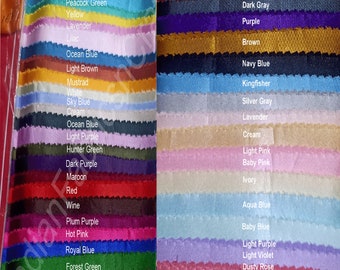 May include: A collection of fabric swatches in a variety of colors, including red, blue, green, and purple. Each swatch is labeled with its color name, such as "Pea Green," "Burgundy," and "Royal Blue."