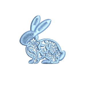 Peut inclure: Un motif de broderie de lapin bleu clair. Le lapin est de profil, les oreilles dressées. Le corps du lapin est rempli d'un motif de filigrane floral. La broderie est sur fond blanc.