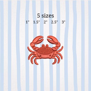 May include: A red crab embroidery design with the text "5 sizes" and size measurements of 1", 1.5", 2", 2.5", and 3". The crab is centered on a blue and white striped background. This design is suitable for nautical-themed projects.