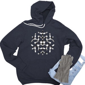 May include: A navy blue hooded sweatshirt with a white and black checkered snowflake design.