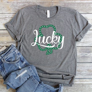 May include: A gray t-shirt with a green shamrock and the word "Lucky" in white text.