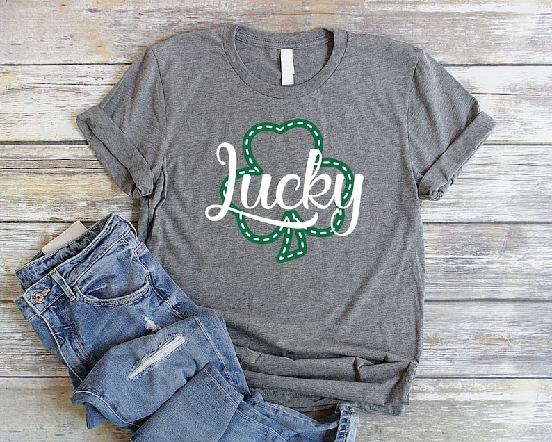 May include: A gray t-shirt with a green shamrock and the word "Lucky" in white text.