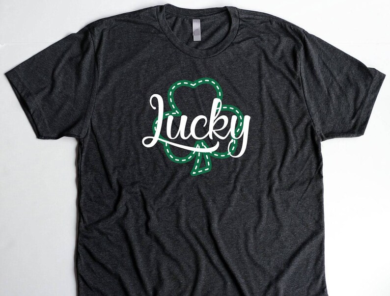 May include: A dark gray t-shirt with a green shamrock and the word "lucky" in white lettering.