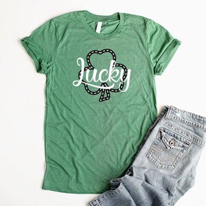 May include: Green t-shirt with a white shamrock design and the word "lucky" in a cursive font.