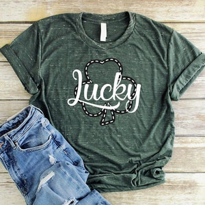 May include: A green t-shirt with a white shamrock and the word "lucky" in a white cursive font.