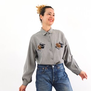 Vintage 80´s novelty embroidered shirt for women. This 80s kitsch shirt with embroidery of suitcases for a long trip has long sleeve and , collared, and lined button front, it´s boxy shape and loose fit. Size M or L
