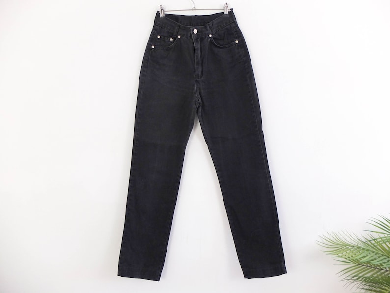 May include: Black high-waisted jeans with a straight leg fit.