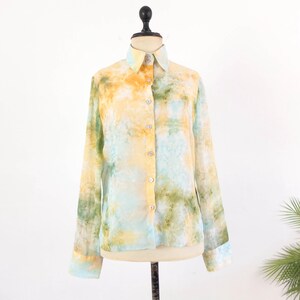 Op de afbeelding: Een overhemd met lange mouwen en een aquarelpatroon in geel, groen en blauw. Het overhemd heeft een kraag en manchetten en wordt gepresenteerd op een paspop tegen een witte achtergrond.
