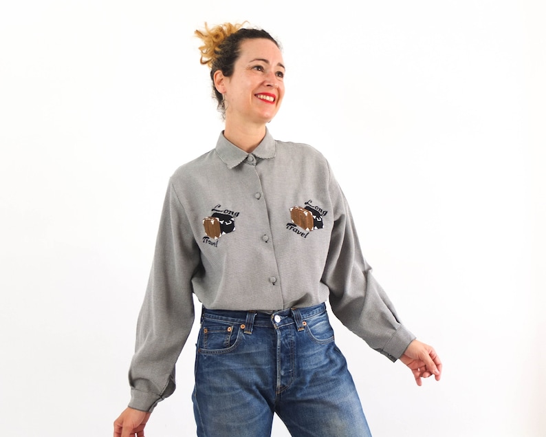 Vintage 80´s novelty embroidered shirt for women. This 80s kitsch shirt with embroidery of suitcases for a long trip has long sleeve and , collared, and lined button front, it´s boxy shape and loose fit. Size M or L