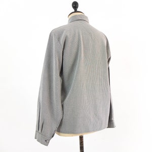 May include: A gray long-sleeved button-up shirt with a subtle pattern.