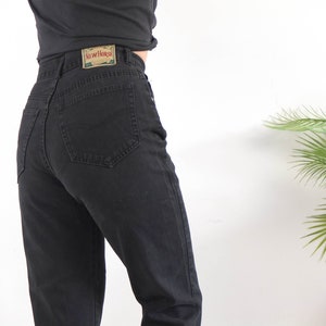 May include: Black high-waisted jeans with a