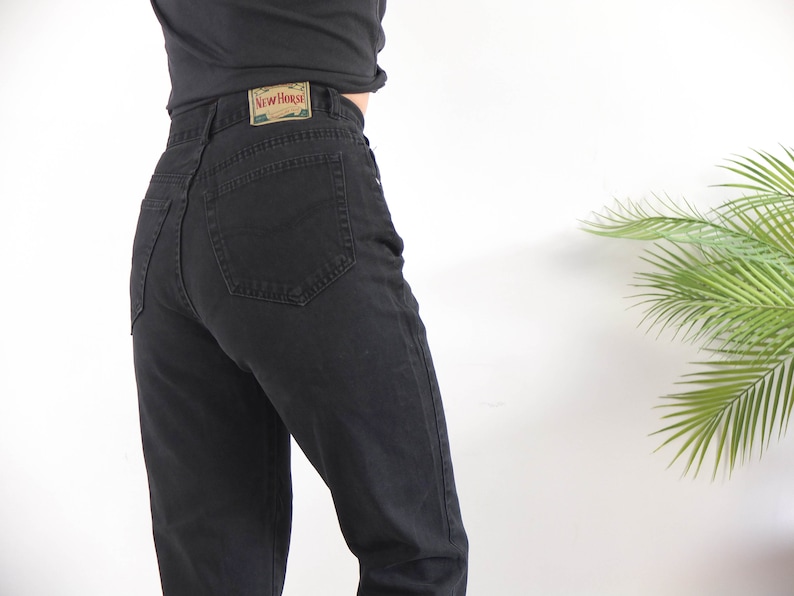 May include: Black high-waisted jeans with a