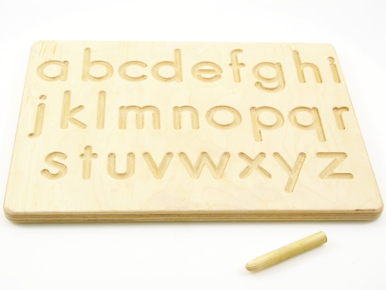 Peut inclure: Planche de tra&ccedil;age en bois de l'alphabet avec un stylet. La planche pr&eacute;sente l'alphabet entier en minuscules grav&eacute; dans la surface.