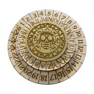 May include: A wooden circular puzzle with three rotating rings. The outer ring has numbers 1 through 20, the middle ring has letters A through Z, and the inner ring has numbers 1 through 14. The center of the puzzle features a carved skull with a starburst design.