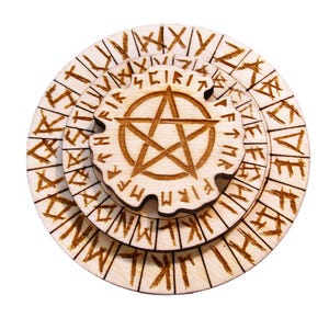 Może przedstawiać: Trzypoziomowa drewniana układanka z pentagramem pośrodku. Układanka jest jasnobrązowa z wytrawionymi symbolami i runami na krawędziach. Środkowy element ma wzór gwiazdy.