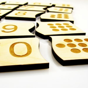 May include: Wooden number tiles with black edges, featuring the numbers 1 through 10. Each tile also has a corresponding number of dots.