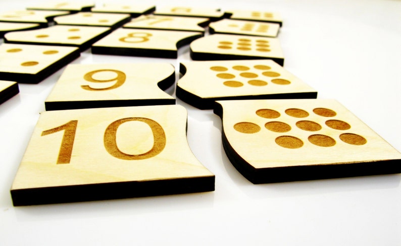 May include: Wooden number tiles with black edges, featuring the numbers 1 through 10. Each tile also has a corresponding number of dots.