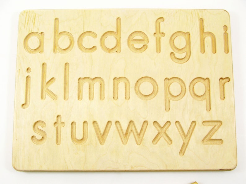Peut inclure: Planche de tra&ccedil;age en bois de l'alphabet avec les lettres de a &agrave; z grav&eacute;es &agrave; la surface. La planche est de couleur brun clair et a une finition lisse.