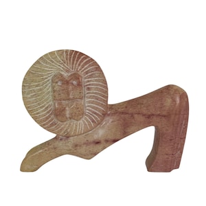 May include: A carved stone lion sculpture in shades of tan and reddish-brown. The lion is depicted in a side profile, with a detailed mane and a stylized body. The sculpture is likely a decorative item.