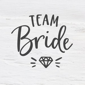 Könnte beinhalten: Weißer Holzgrund mit schwarzem Text, der "Team Bride" lautet, mit einer Diamantgrafik darunter.