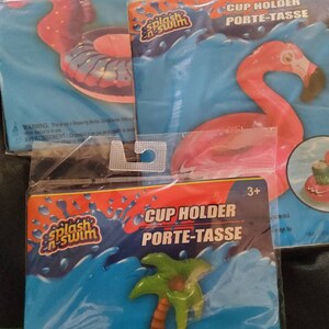 May include: Three inflatable cup holders for pool parties. The first is a pink flamingo, the second is a seahorse with a donut, and the third is a palm tree. All three have the words "Splash 'n Swim" on the packaging.