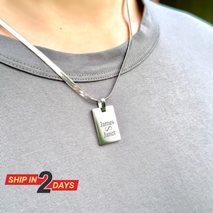 May include: Silver chain necklace with a rectangular pendant engraved with the names "James" and "Janet" and an infinity symbol.