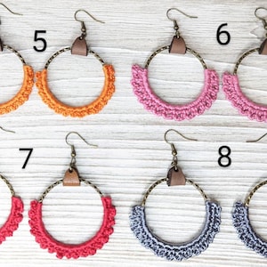 May include: Crocheted hoop earrings with leather accents in orange, pink, red, and gray. The earrings are numbered 5, 6, 7, and 8.