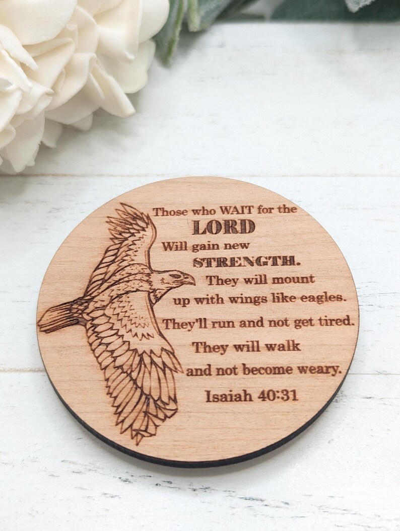 Pu&ograve; includere: Un cartello rotondo in legno con un'immagine di un'aquila in volo incisa al laser. Il cartello presenta il testo "Those who WAIT for the LORD Will gain new STRENGTH. They will mount up with wings like eagles. They'll run and not get tired. They will walk and not become weary. Isaiah 40:31"
