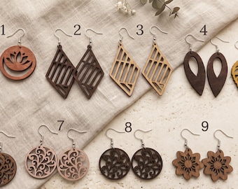 May include: Ten pairs of wooden dangle earrings with silver-toned hooks, numbered one through ten. Designs include circular lotus cutouts, geometric diamonds, teardrops, leaf shapes, intricate swirls, floral patterns, and a small blue pointed shape.