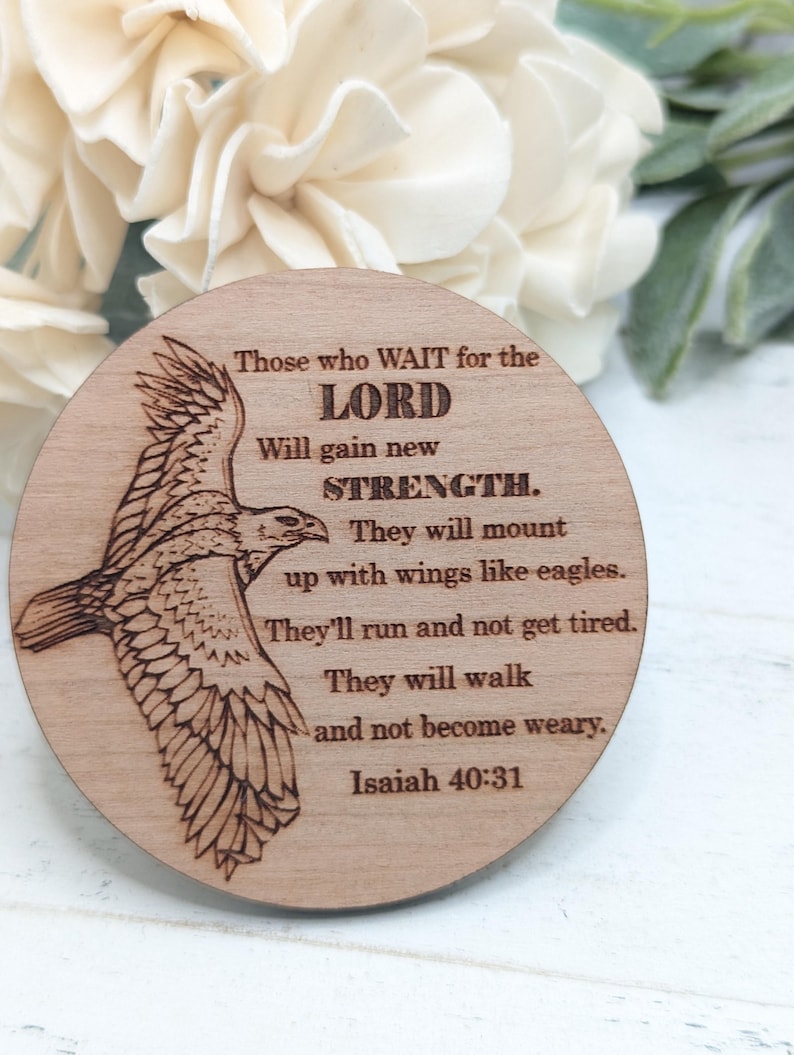 Pu&ograve; includere: Un cartello rotondo in legno con un'immagine di un'aquila in volo incisa a fuoco. Il cartello contiene un versetto biblico di Isaia 40:31, "Quelli che aspettano il SIGNORE rinnoveranno le loro forze; monteranno con ali come aquile; correranno e non si stancheranno, cammineranno e non si affaticheranno. Isaia 40:31"