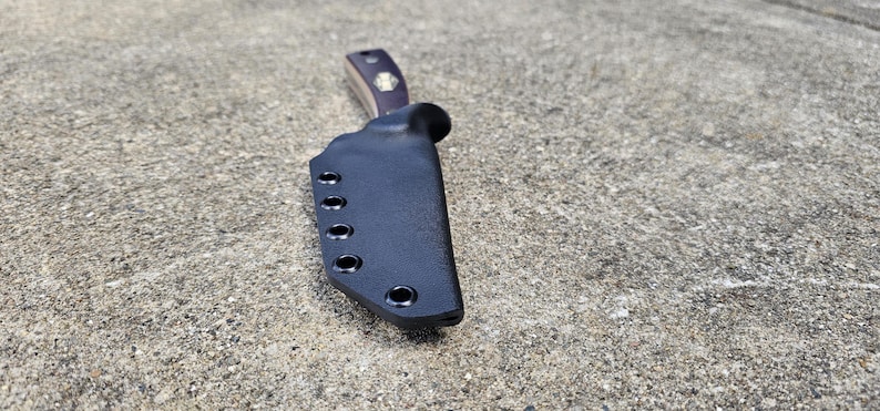 May include: Black leather knife sheath with multiple snap closures.
