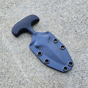 以下が含まれることがあります： 黒色のタクティカルナイフ。グリップはテクスチャ加工されており、T字型で握りやすい。鞘には複数のアイレットがあり、取り付け可能です。