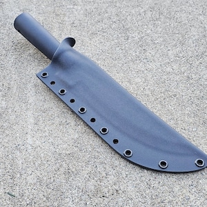 May include: A dark gray knife sheath with a cylindrical handle and a blade cover. The sheath has multiple eyelets along the edge and is made of a durable material. The sheath is designed to protect a knife.