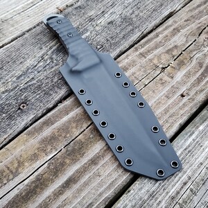 May include: Black knife sheath with multiple grommets for belt attachment.