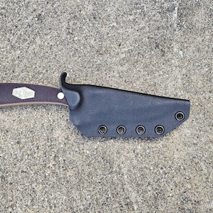 May include: A black leather knife sheath with six belt loops. The sheath has a brown wooden handle with a silver accent.