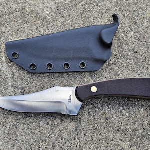 May include: A black leather knife sheath with a brown wooden handle knife with a silver blade. The blade has the text "152mm" on it.