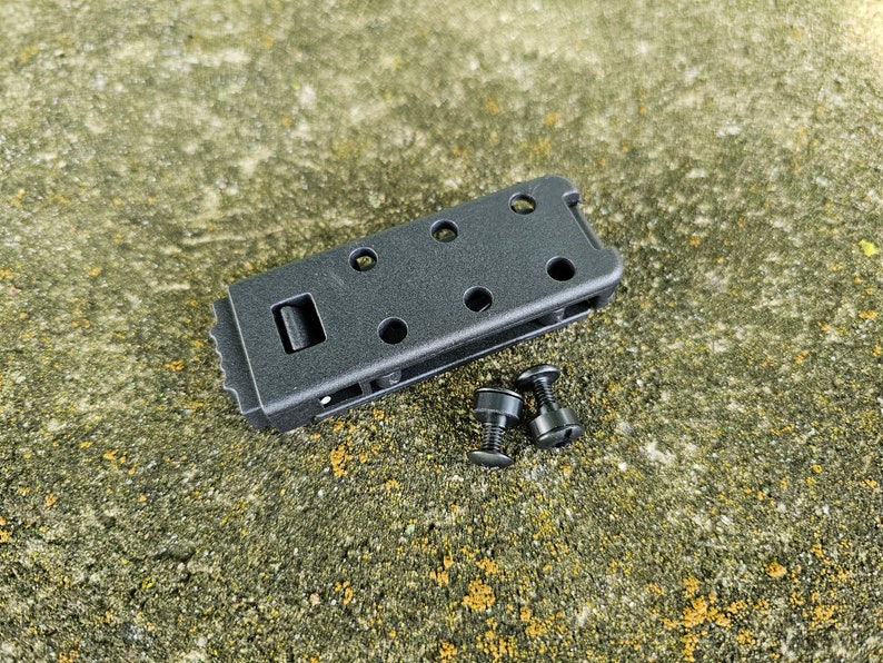 May include: Black plastic clip with a textured surface and multiple holes. Two black screws are included.