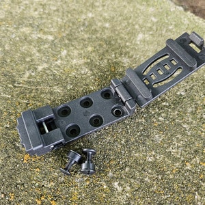 May include: Black plastic belt clip with a folding mechanism and multiple holes. Two black screws are included.