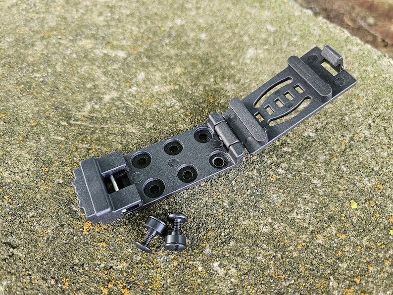 May include: Black plastic belt clip with a folding mechanism and multiple holes. Two black screws are included.