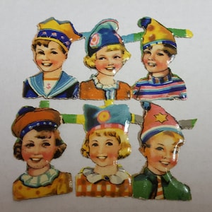 18 enfants dans des chapeaux de fête : chutes de papier découpées avec des matrices de papier autrichien Heller des années 1950 représentant des visages d'enfants