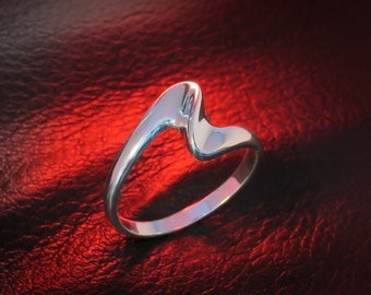 May include: A silver ring with a unique, abstract design. The ring is smooth and shiny, and the band is curved and twisted.