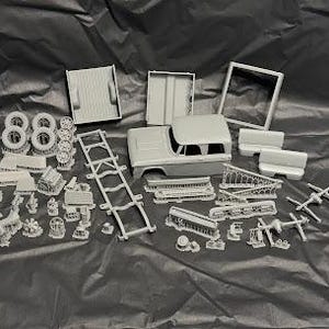 Peut inclure: Une maquette de voiture avec différentes pièces en plastique gris, y compris la carrosserie, le châssis, les roues et les composants intérieurs. La maquette semble être pour une voiture ancienne.
