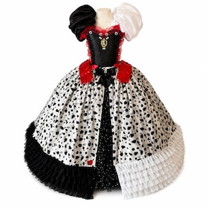 cruella red and black dress REBEL IN RED This is Emma Stone's fourth look as Cruella De Vil in Cruella (2021). She wears a black military jacket with gold detailing, a gold sash with the words 'the